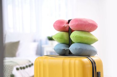 Yatak odasındaki bavulda boyun yastıkları. Seyahat kavramı