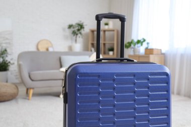 Oturma odasının iç tarafına mavi bavul konmuş.