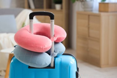 Boyun yastıkları ve bavul odada. Seyahat kavramı