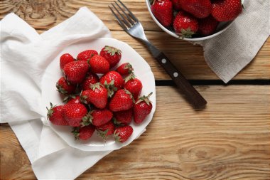 Ahşap arka planda taze çilekli bir tabak.