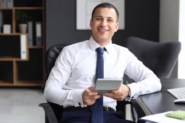 Hesap makineli erkek muhasebeci ofiste oturuyor.