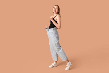 Bej arka planda bol kotlu genç bir kadın. Kilo verme konsepti