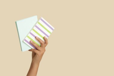 Bej arkaplan üzerine not defterleri olan çocuk