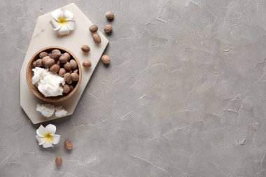 Bir kase kabak ezmesi, fındık ve fındık çiçekli gri arka plan.