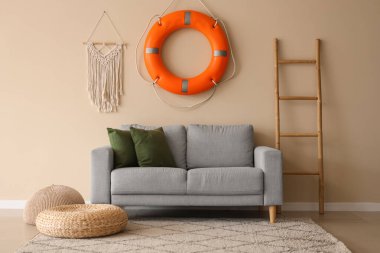 Sıcak kanepe, merdiven, can simidi yüzüğü ve puflar oturma odasında.