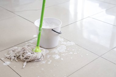 Yurt odasında yerde kovayla ıslak paspas, yakın plan.