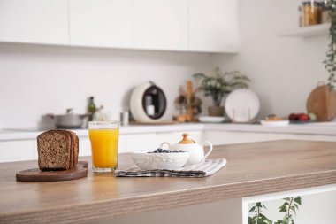 Mutfaktaki masada meyve suyu ve ekmek olan yabanmersini, yakın plan.