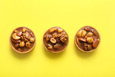 Fındıklı lezzetli tartlar ve sarı arka planda karamel.