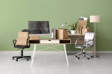 Taşınma gününde içinde karton kutular ve sandalyeler olan masalar