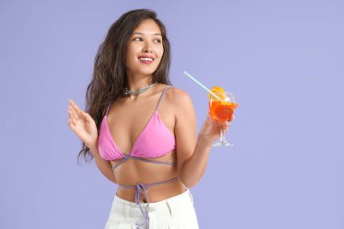 Leylak arka planında aperol sprey kokteyli olan genç Asyalı kadın.