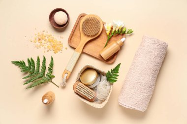 Renkli arkaplanda spa aksesuarları, kozmetik ürünleri ve eğreltiotu yaprakları ile kompozisyon