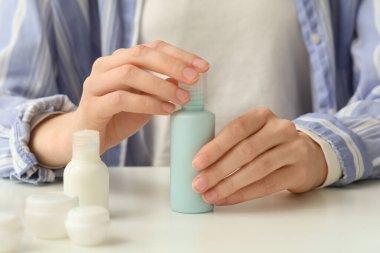 Seyahat kozmetik ürünleri olan kadın ışık masasında, yakın plan