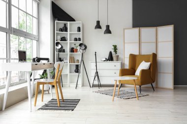 İş yeri, koltuk ve ekipmanlı fotoğrafçı bürosu.