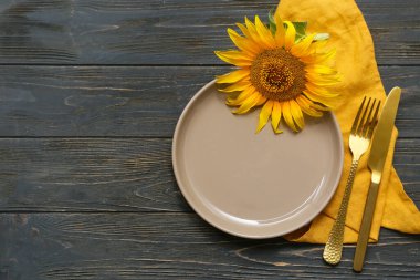 Siyah ahşap zemin üzerinde ayçiçeği olan güzel bir masa.