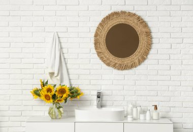 Vazo ve ayçiçekleri lavabonun yanında tuvaletteki çekmecelerin üstünde.