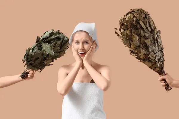 stock image Shocked young woman in sauna hat and hands with whisks on brown background