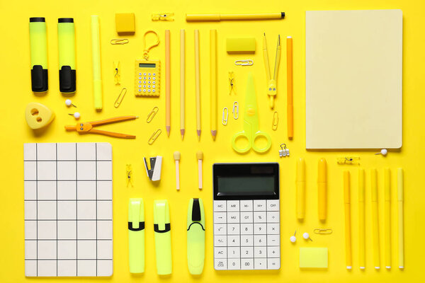 Школьные принадлежности на жёлтом фоне. Вид сверху