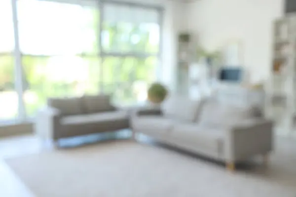 stock image Blurred view of living room with grey sofas and workplace