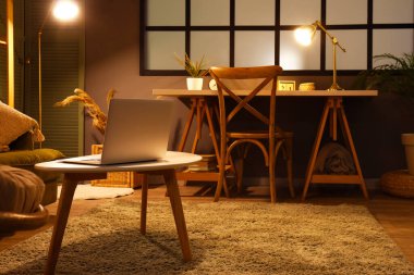 Modern dizüstü bilgisayarlı ahşap sehpa oturma odasının içinde, yakın plan.