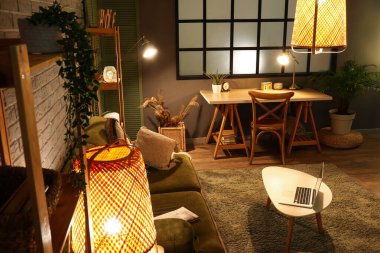 Masada modern dizüstü bilgisayarı ve kanepesi olan şık bir oturma odası.