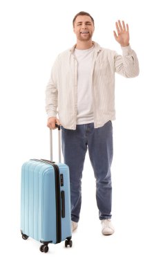 Beyaz arka planda mavi valizli mutlu genç adam.