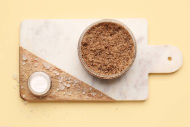 Renk arka planında vücut fırçası, krema ve deniz tuzu olan tahta