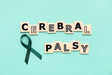 Turkuaz zemin üzerinde CEREBRAL PALSY yazılı saten yeşil kurdele ve plastik harfler