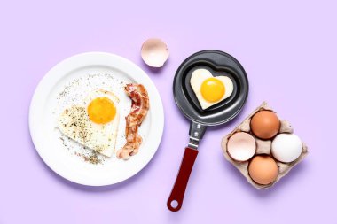 Kızartma tavasında kalp şeklinde sahanda yumurta ve leylak arkaplanda kızarmış yumurta ve pastırma kompozisyonu.