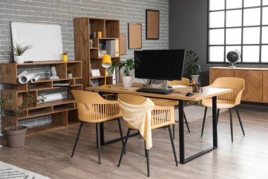 Çalışma yeri, raf üniteleri ve bitkileri olan şık bir ofis.