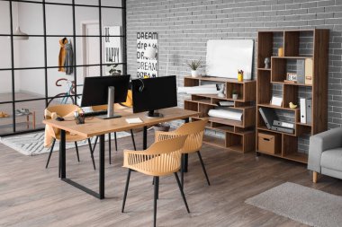 Çalışma yeri, raf üniteleri ve bitkileri olan şık bir ofis.