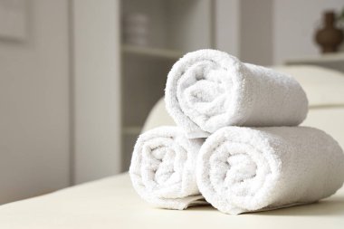 Beyaz kanepeye sarılmış yumuşak havlular, yakın plan.