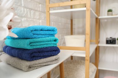 Beyaz masaya temiz yumuşak havlular yığını, yakın plan.