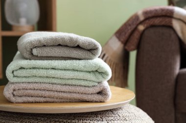 Evdeki ahşap tepside temiz yumuşak havlular yığını, yakın çekim.