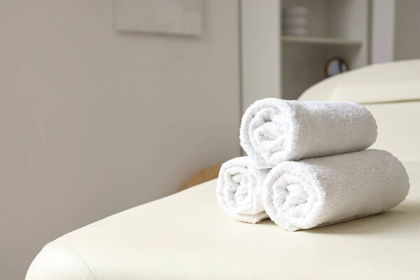 Clean soft towels on white couch, closeup