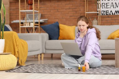 Boğazı, dizüstü bilgisayarı ve ilacı olan hasta genç bir kadın.