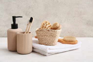 Banyodaki grunge duvarının yanında temiz yumuşak havlular ve banyo malzemeleri, yakın plan.