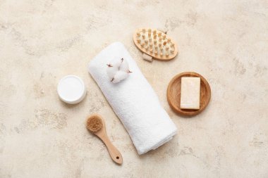 Temiz yumuşak havluyla güzel bir kompozisyon ve arkaplanda banyo malzemeleri.