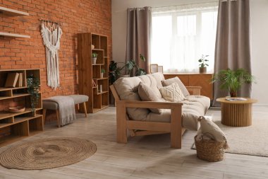 Oturma odasının iç tarafında rahat bir kanepe ve raf var.