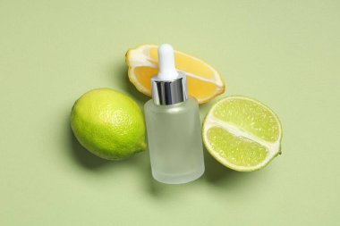 Yeşil arka planda turunçgil meyveleri ve bir şişe kozmetik ürünle kompozisyon, yakın plan.