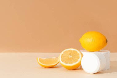 Bej arka planda kozmetik ürün kavanozları ve limonlarla kompozisyon