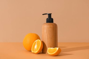 Kahverengi arka planda bir şişe kozmetik ürünü ve portakallı kompozisyon