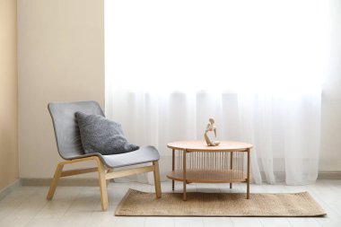 Kahve masası ve sandalye odada ışık perdesinin yanında.