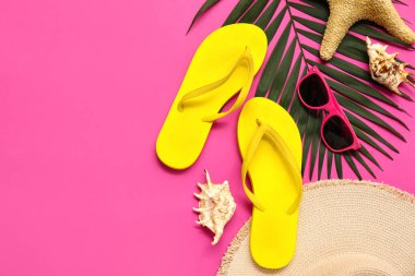 Pembe arka planda deniz kabukları, güneş gözlüğü ve tropikal yaprak olan terlikler.