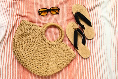 Saman çantalı terlikler ve tekstil arka planında güneş gözlüğü.