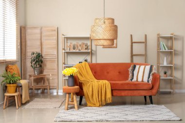 Oturma odasında ekose ve güzel nergislerle dolu rahat bir kanepe.