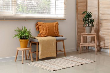 Oturma odasında yastıklı ve ekose banklı.