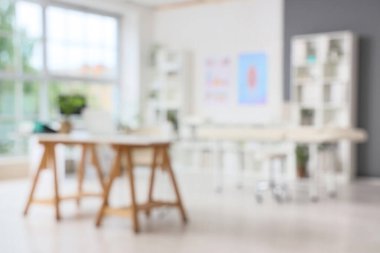 Çalışma yerleri, masaj koltuğu ve raf üniteleri olan bulanık tıbbi ofis manzarası