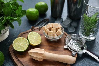 Ahşap tepsi, çalkalayıcı, tokmak ve mavi arkaplanda mojito malzemeleri, yakın plan.