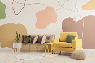 Rahat koltuk, lamba ve oturma odasının içinde yastıklar olan raf.