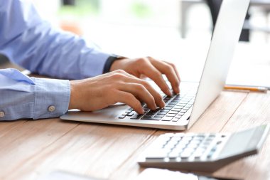 Ofiste dizüstü bilgisayarla çalışan erkek muhasebeci, yakın plan.